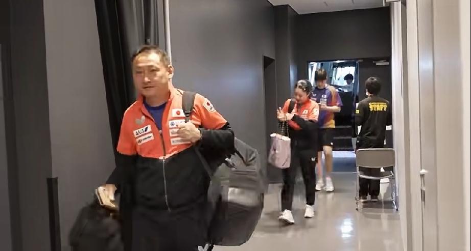 张本宇带着兄妹俩从后台走过。张本智和，张本美和俩人都背着包，后台遇到记者张本美