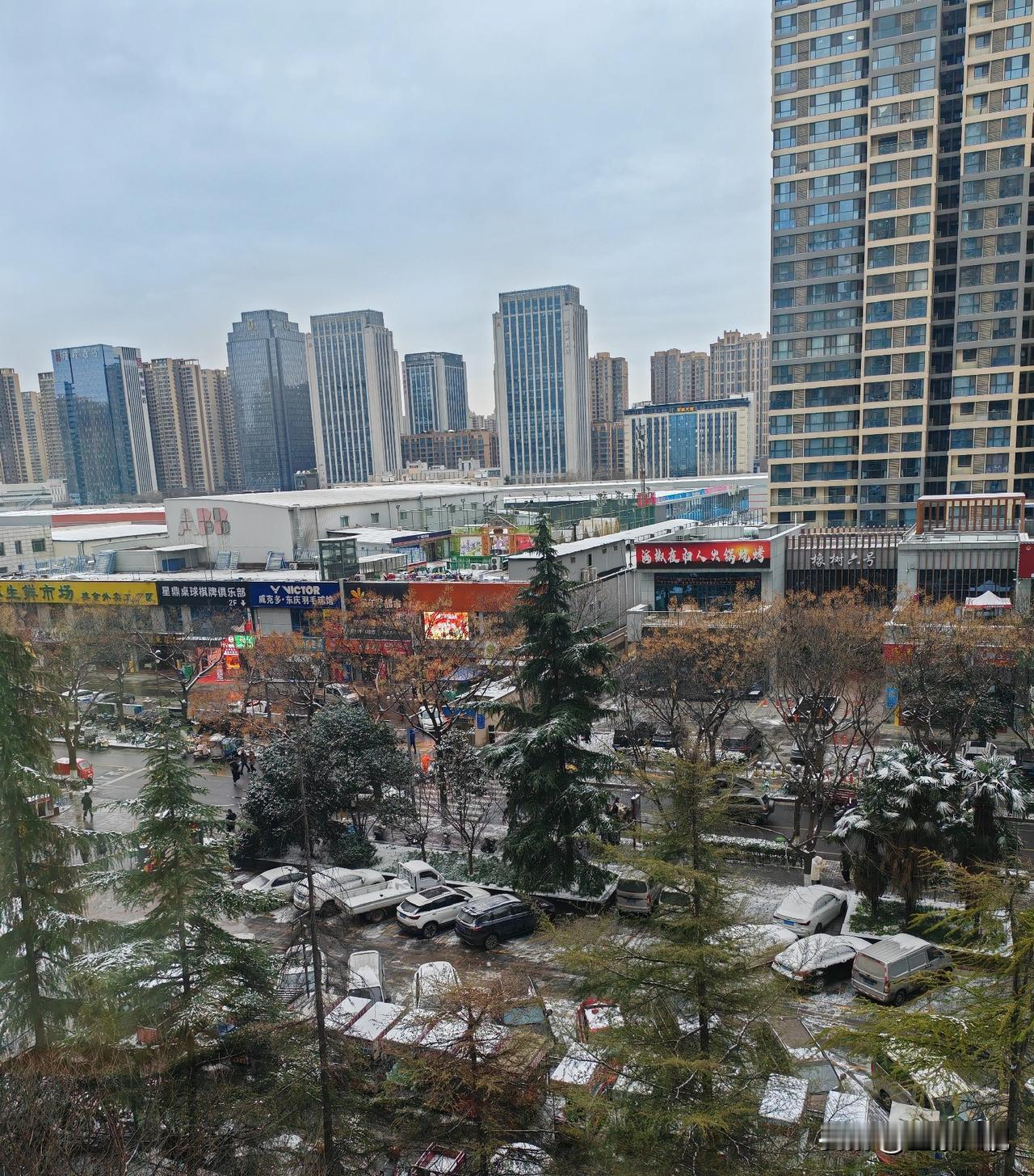 大家看看所谓的暴雪后的西安城北，只有屋顶和树木上能看到一点雪。