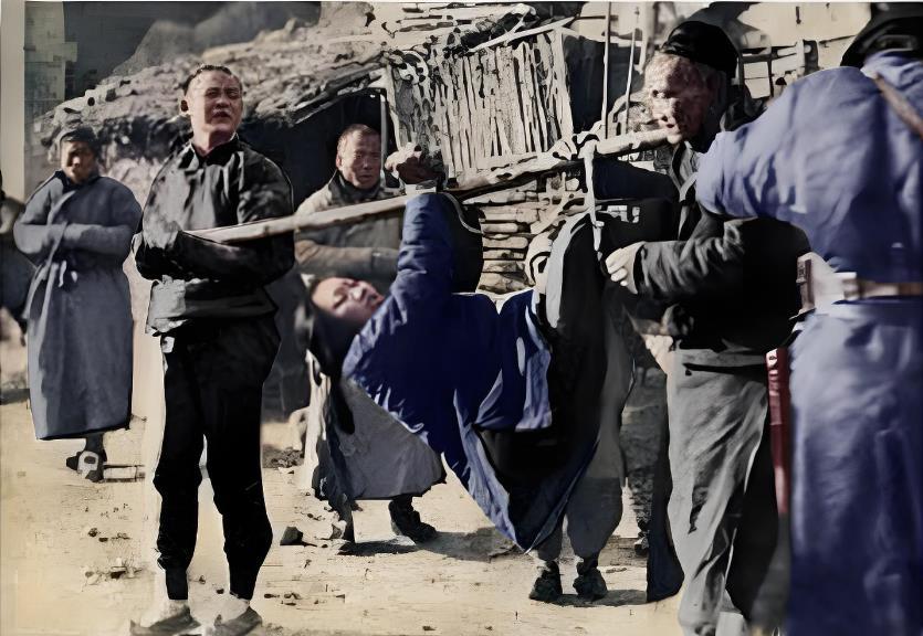 1942年12月28日，华北，一名年轻女子被反绑双手，像捆猪一样横卧在一根粗木杠