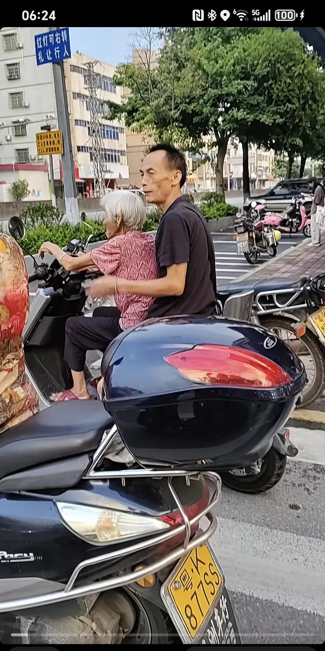 佩服这位大哥，怕他老母亲在后面坐不好～这个大哥应该是怕他妈妈坐后面不安全，所以