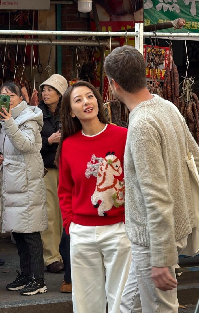 就在成都玉林菜市场遇到水灵灵的高圆圆了她梳着披肩长发，穿着红色毛衣配白色宽松裤