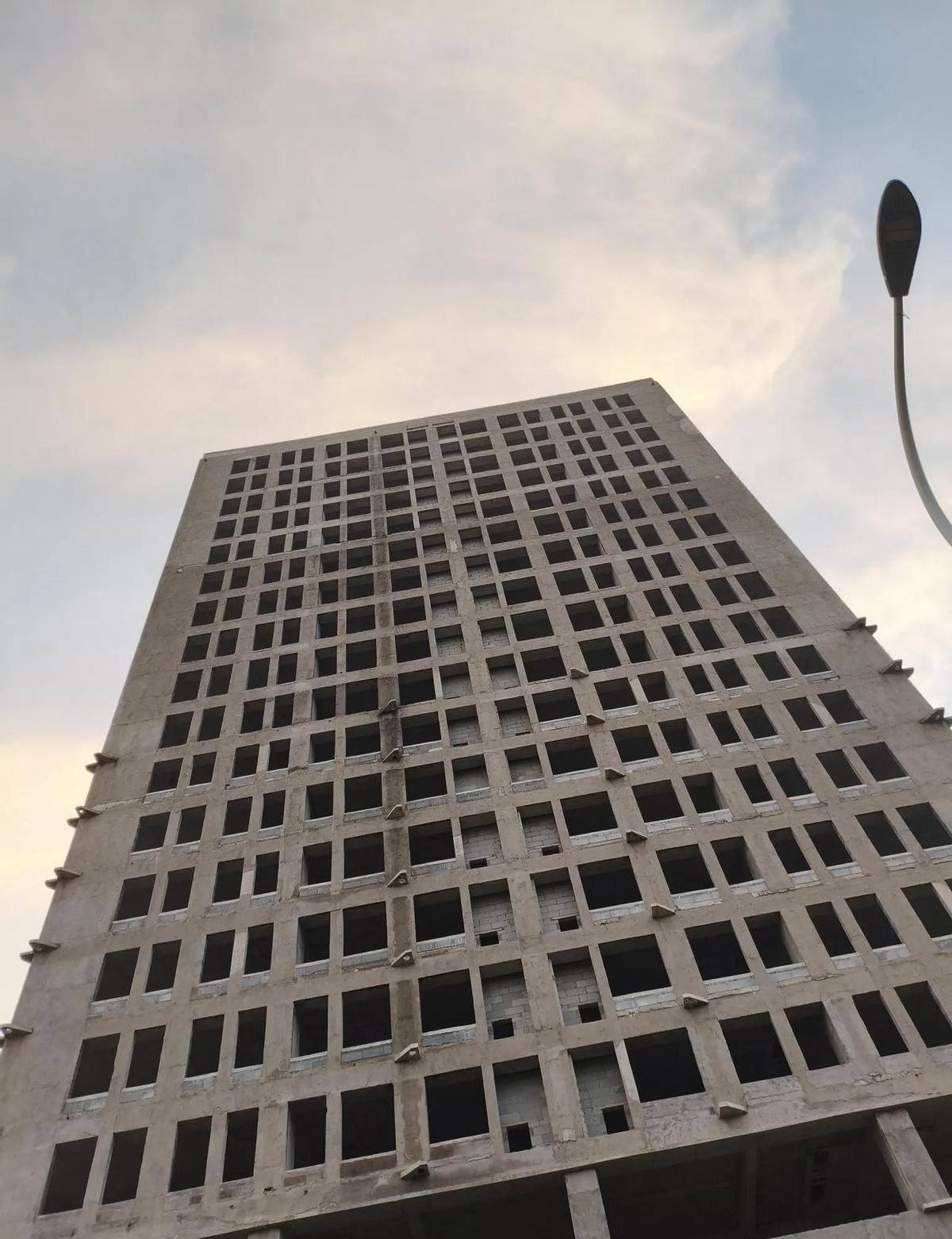 这栋楼，从2014年打完地基，就再没动过。钢筋裸着，玻璃空着，墙皮没刮，电梯没