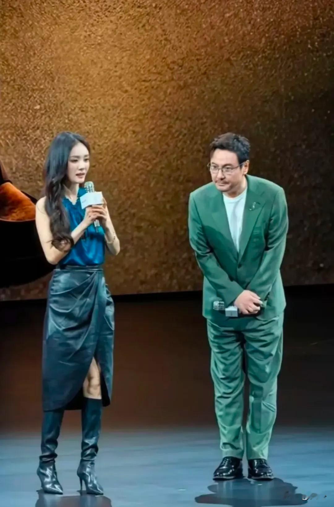 享界G9发布会，杨幂和沈腾同台，一个负责美一个负责搞笑。杨幂穿深蓝挂脖上衣配黑色皮裙，蓝色跟新车云沙