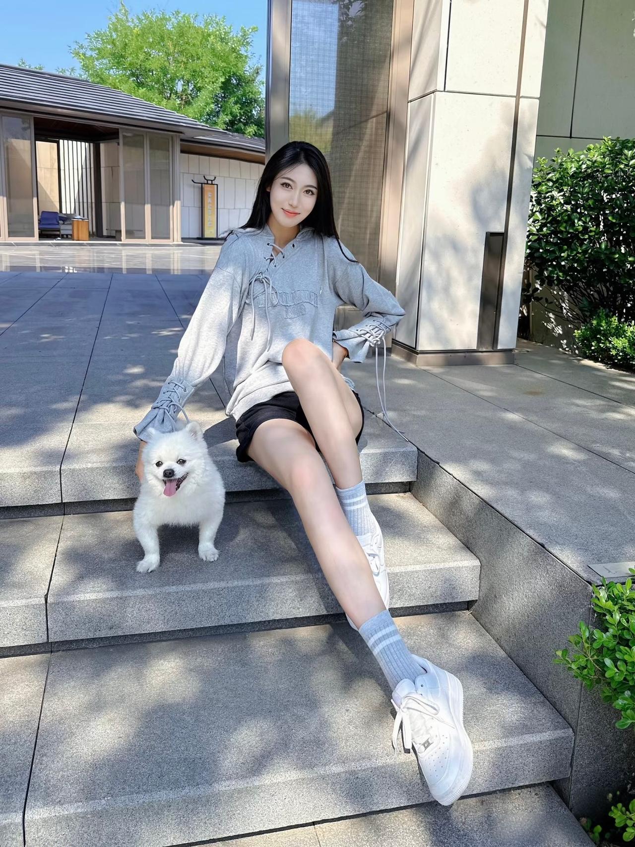阳光明媚，女孩和狗狗在台阶上享受时光。