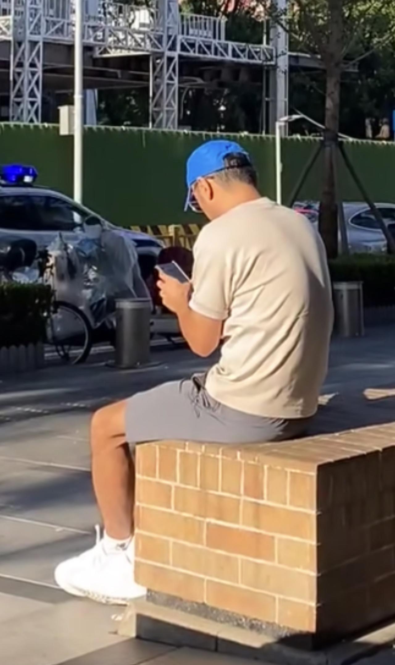 偶遇央视43岁主持人尼格买提，独自在街头坐着，弓着腰玩手机，太低调就像个路人，没