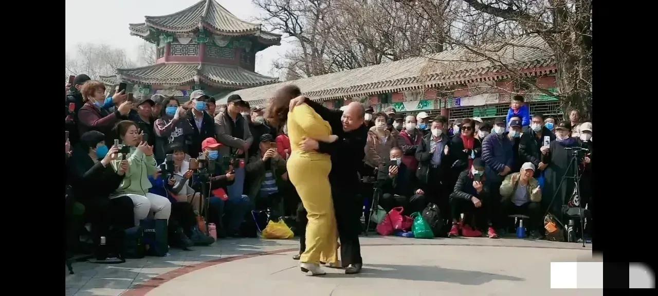 体重超过200斤的一大妈和一位光头大哥在广场上翩翩起舞，四周围满了观众，大家纷纷