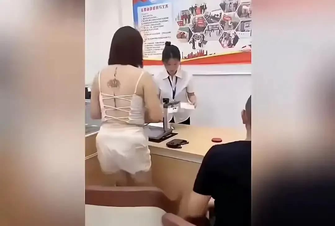 民政局柜台前，女子接过那本暗红色小册子，下一秒直接举过头顶，笑到露八颗牙，原地转