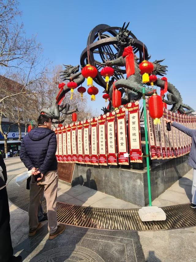 青岛海云庵广场的龙雕塑名为《龙🐉水四放》，上面挂面了“灯迷”，吸引许多观众。