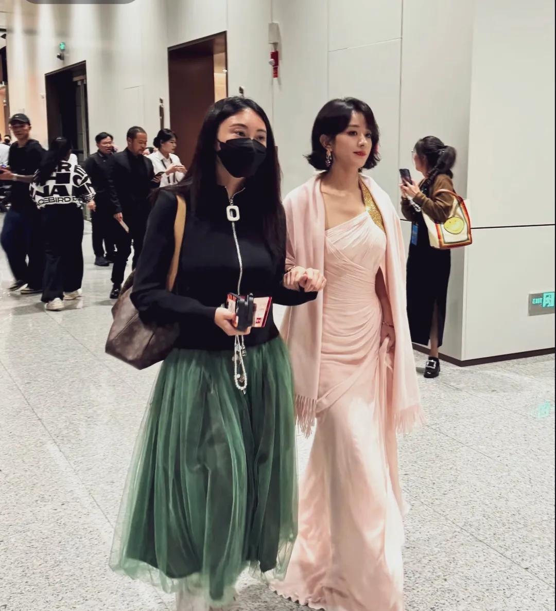 赵丽颖粉色礼服，高台高跟鞋一手扶在助理的手腕上，微微翘起的短发造型，五官立体精致