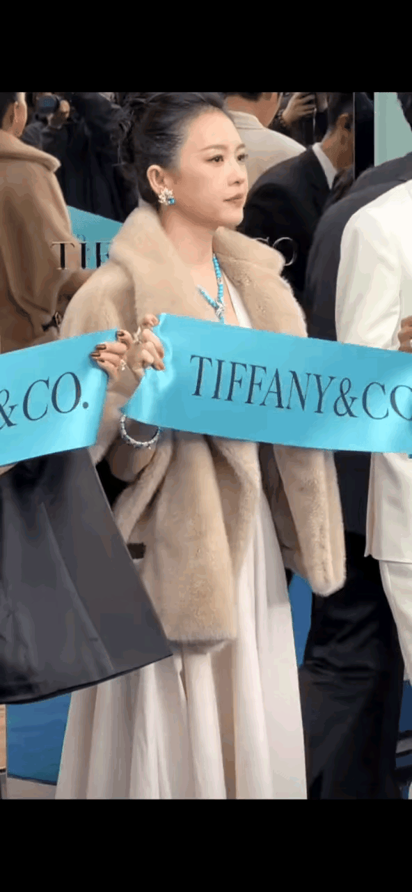 本来很冷，章子怡还把貂皮上衣的领子翻开，露出漂亮昂贵的项链。都说章子怡变了，脸