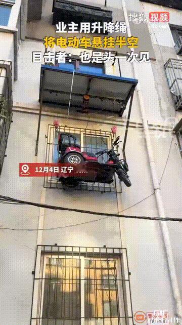 辽宁沈阳一处小区内，一位住在三楼的住户，直接用雨棚里的升降绳，把电动三轮车悬挂在