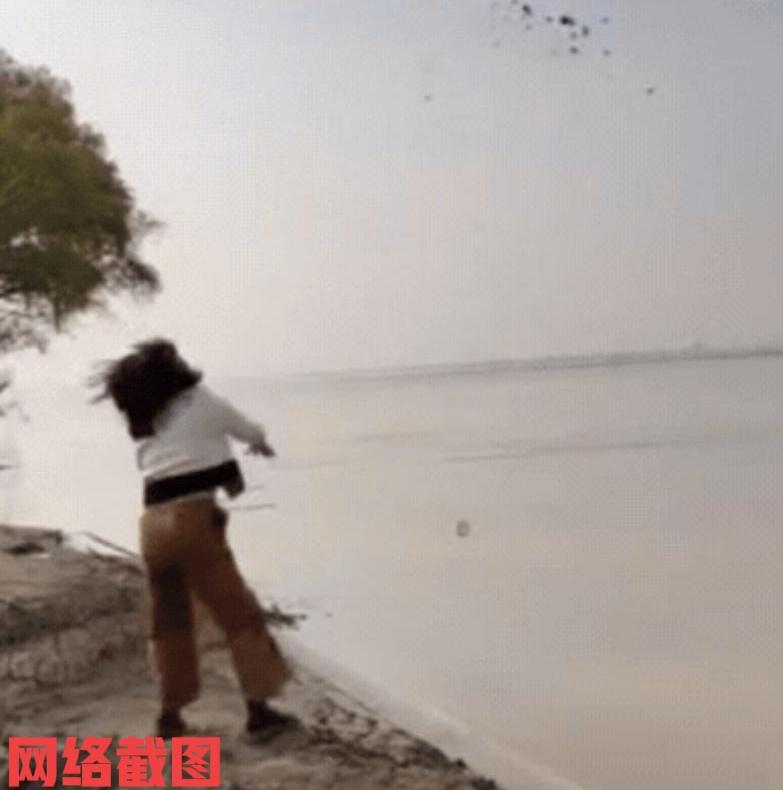 河南有女子和朋友在黄河边玩。女子的心情也是兴奋，便拿起地上的泥块扔向黄河水里