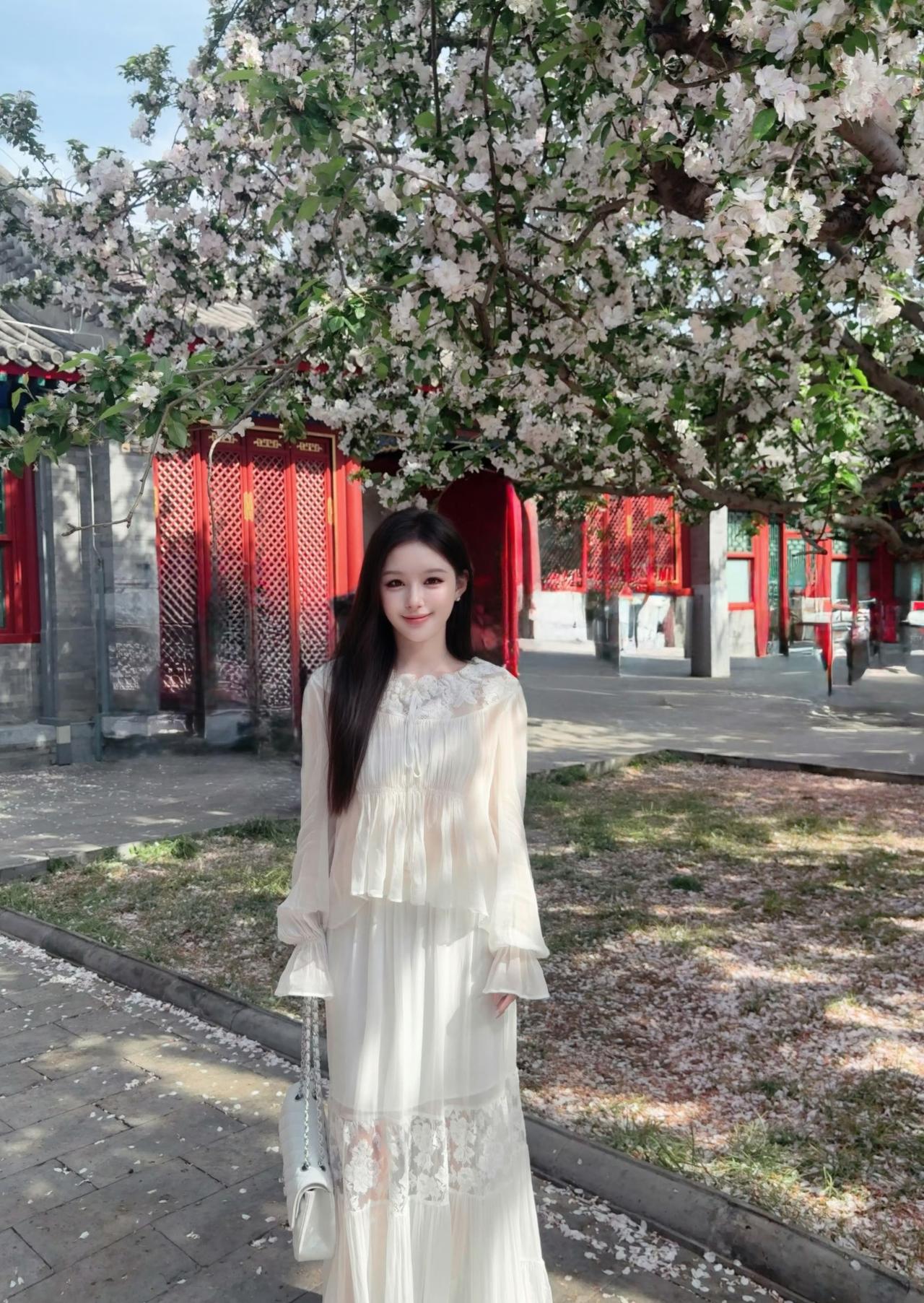 春日的风，把海棠花吹成了一场温柔的雪。一袭白裙轻晃，裙摆与落樱共舞，将春天的浪漫
