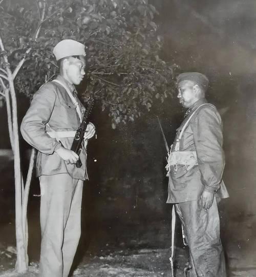 这张照片记录的是1958年，时任南京军区司令员的许世友（右侧）以“上等兵”身份下