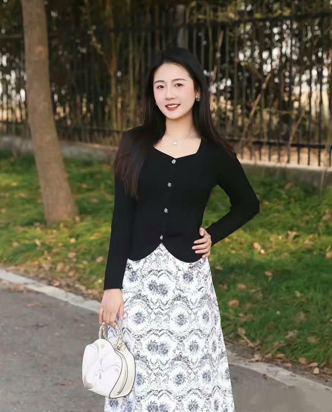 黑色针织衫搭配了一条印花半身裙，简约又不失优雅。