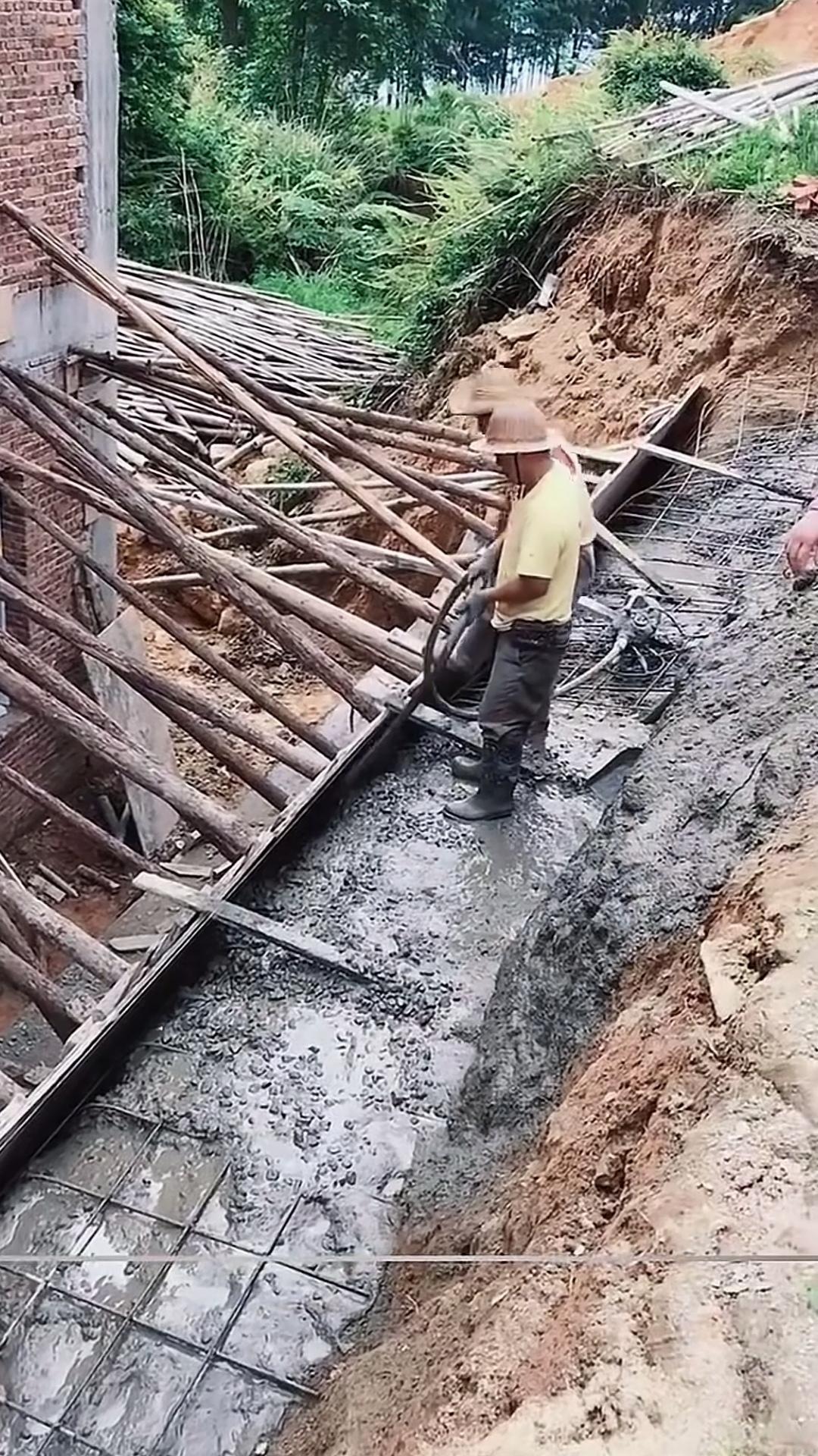 用钢筋水泥浇筑的挡土墙，为何还会遭人质疑？画面里，工人正为挡土墙的第二个基层施