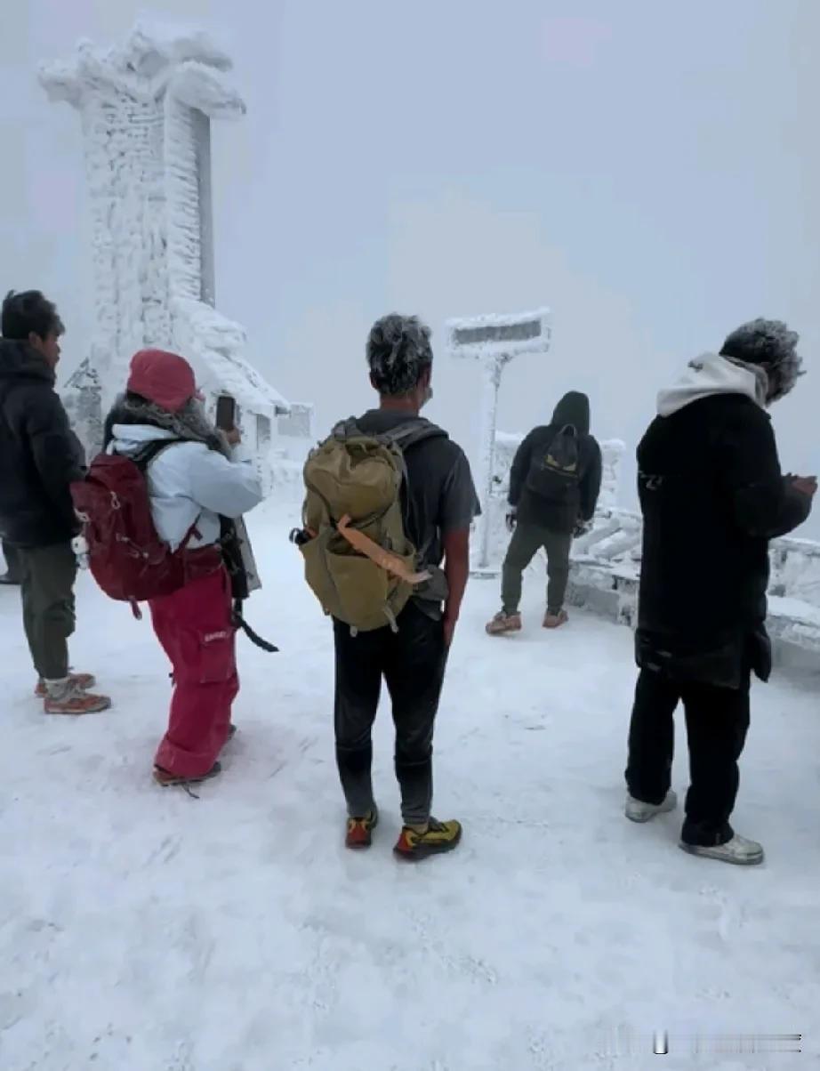 这是海拔1300多米的云冰山山顶呀！寒风凛冽，白雪皑皑，周围的人都是大棉袄，二棉