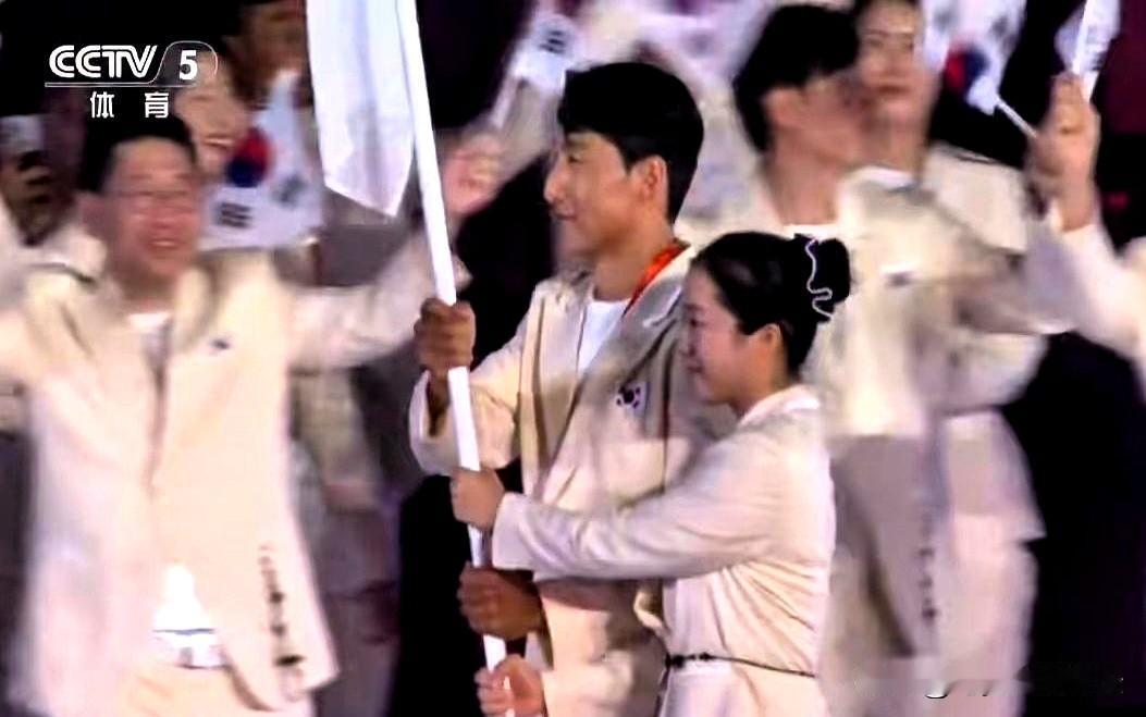 当韩国代表团踏进场地的那一秒，亚运会开幕式的灯光刚好扫过，申裕斌那身影立起来了，