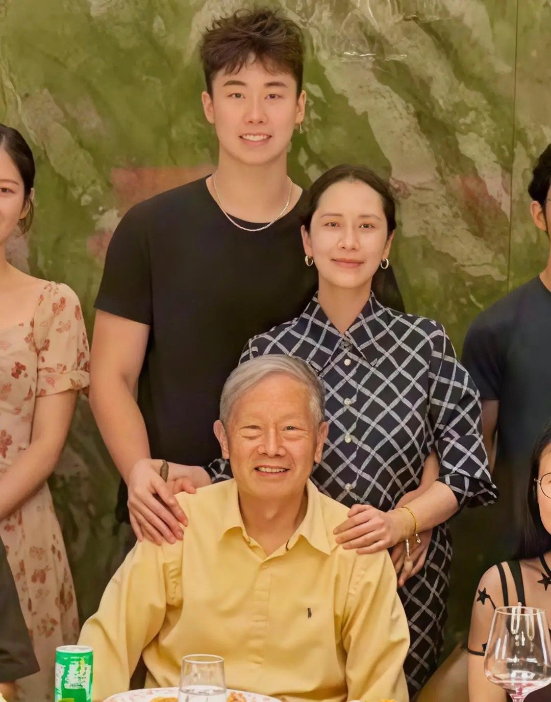 48岁海清带19岁儿子和长辈们一起聚餐，她身穿黑底斜格纹套装，显得她老气多一份从