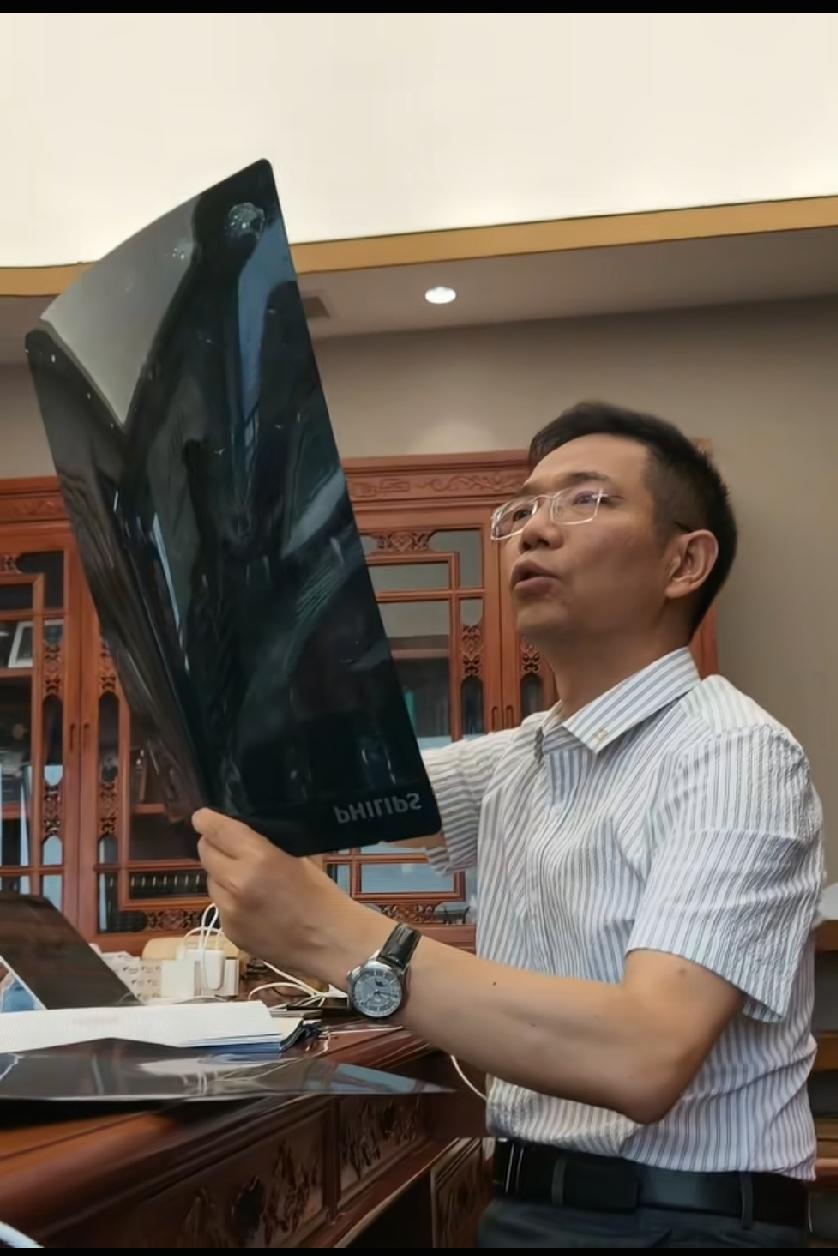 李老师发工作动态：手里拿着片子在看李老师在认真的看着手里面的资料和片子，他现