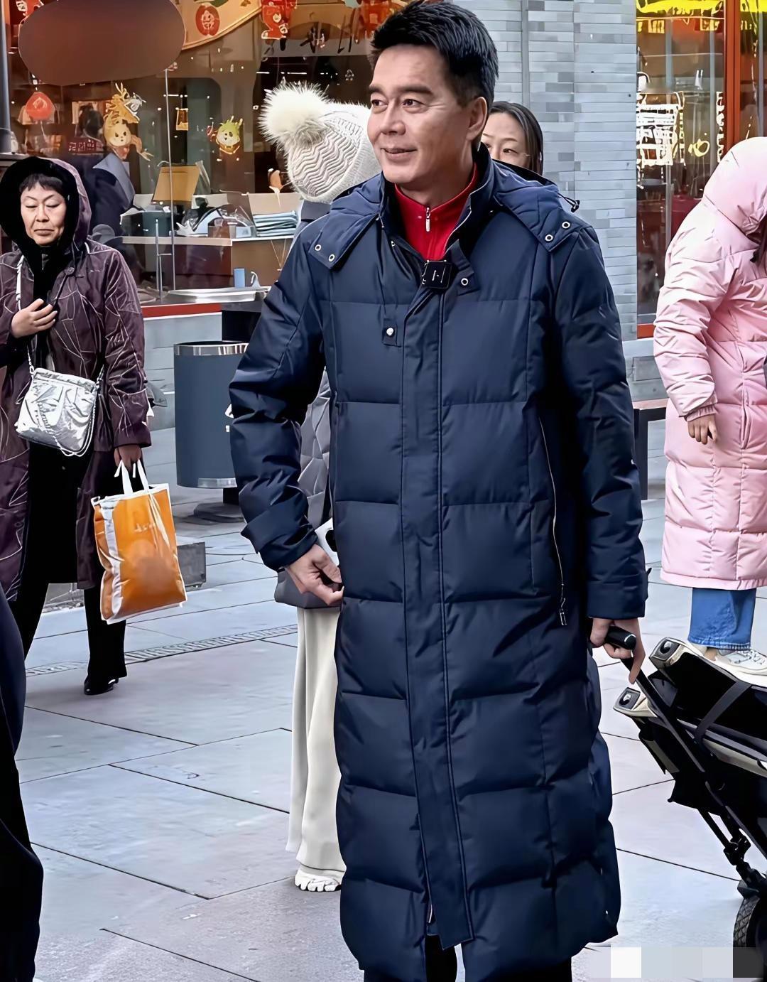 镜头中的许亚军胖瘦合度，衣着时尚，头发乌黑茂盛，眉毛清晰疏朗，容颜明亮俊逸，眼角