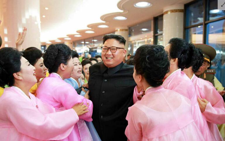 金正恩站在红装军装的女子之间笑得很灿烂，她们看到他都很激动。