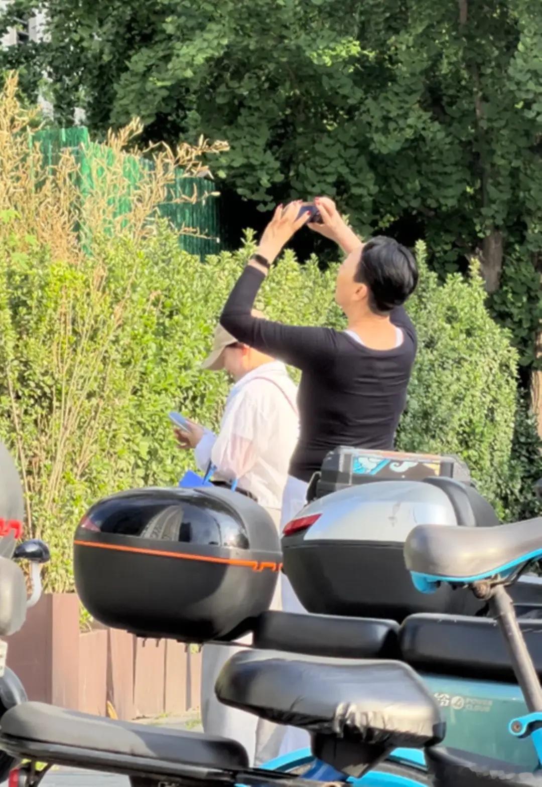 宋丹丹北京街头拍云彩，65岁染红指甲，长胖了穿吊带背心露出副乳！