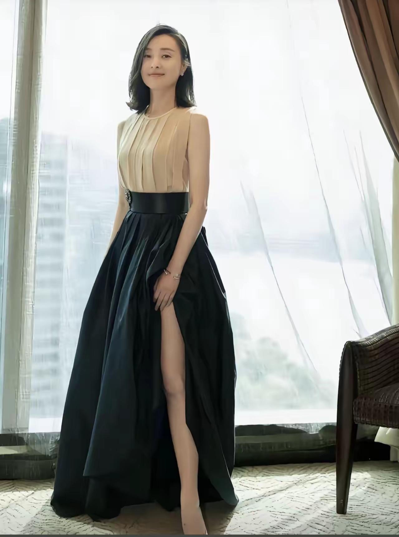 吴越年龄越大越不老实了，裙子开叉太高都需要用手捂着了！像她这样没有老公的人，尽量