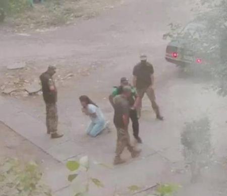 乌克兰一名为了自由和美好欧盟生活的乌克兰女子跪在地上，恳求乌克兰绑匪不要把她的丈
