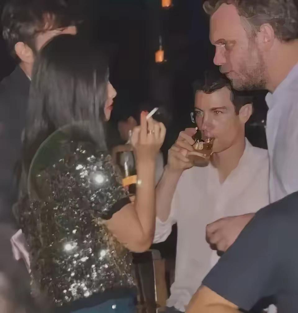 朱珠早期在国外的生活照曝光，她穿亮片衣吐舌头，手里还拿着香烟，身边都是帅气的外国