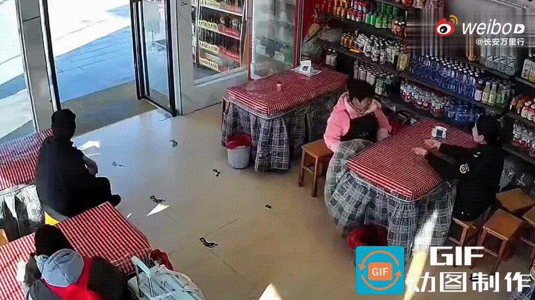 食客们坐在面馆里津津有味地吃着面条，突然一辆红色轿车推着一个圆形石墩子直撞进来，