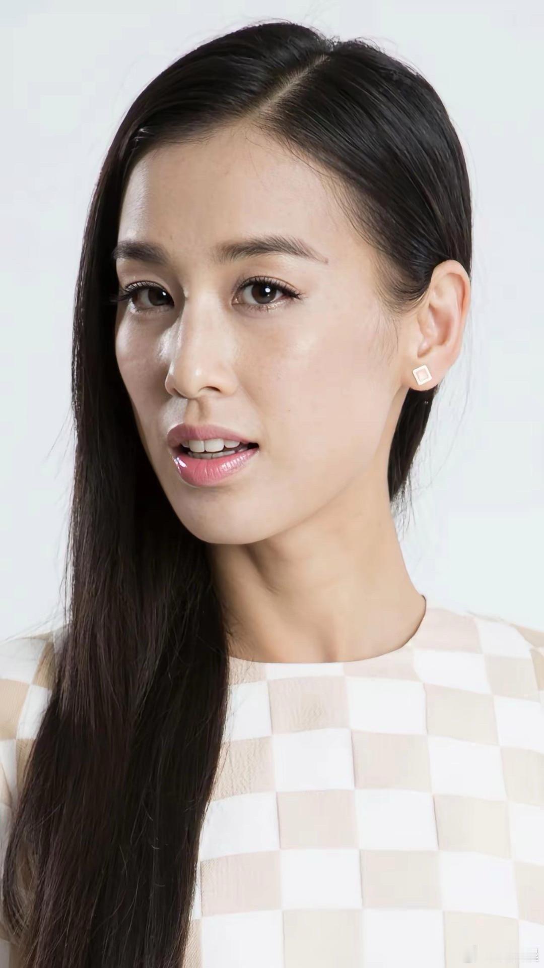 黄圣依长发披肩浅笑嫣然，一袭时尚格纹小上衣加身，尽显优雅大方的气质。