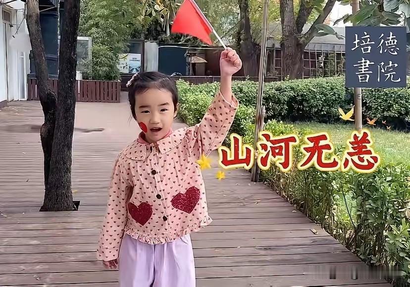 海哈金喜带着女儿李夏参加幼儿园国庆活动，4岁的小姑娘举着小红旗，和小伙伴一起拍视