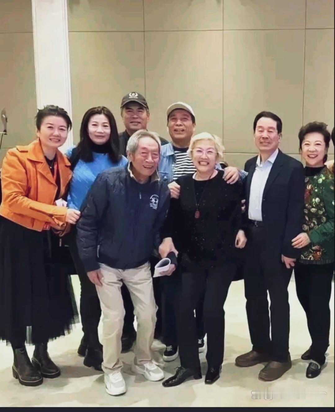 老艺术家们合影，前排王奎荣双腿微曲身体前倾，身旁宋春丽一头银发笑容爽朗，75岁王