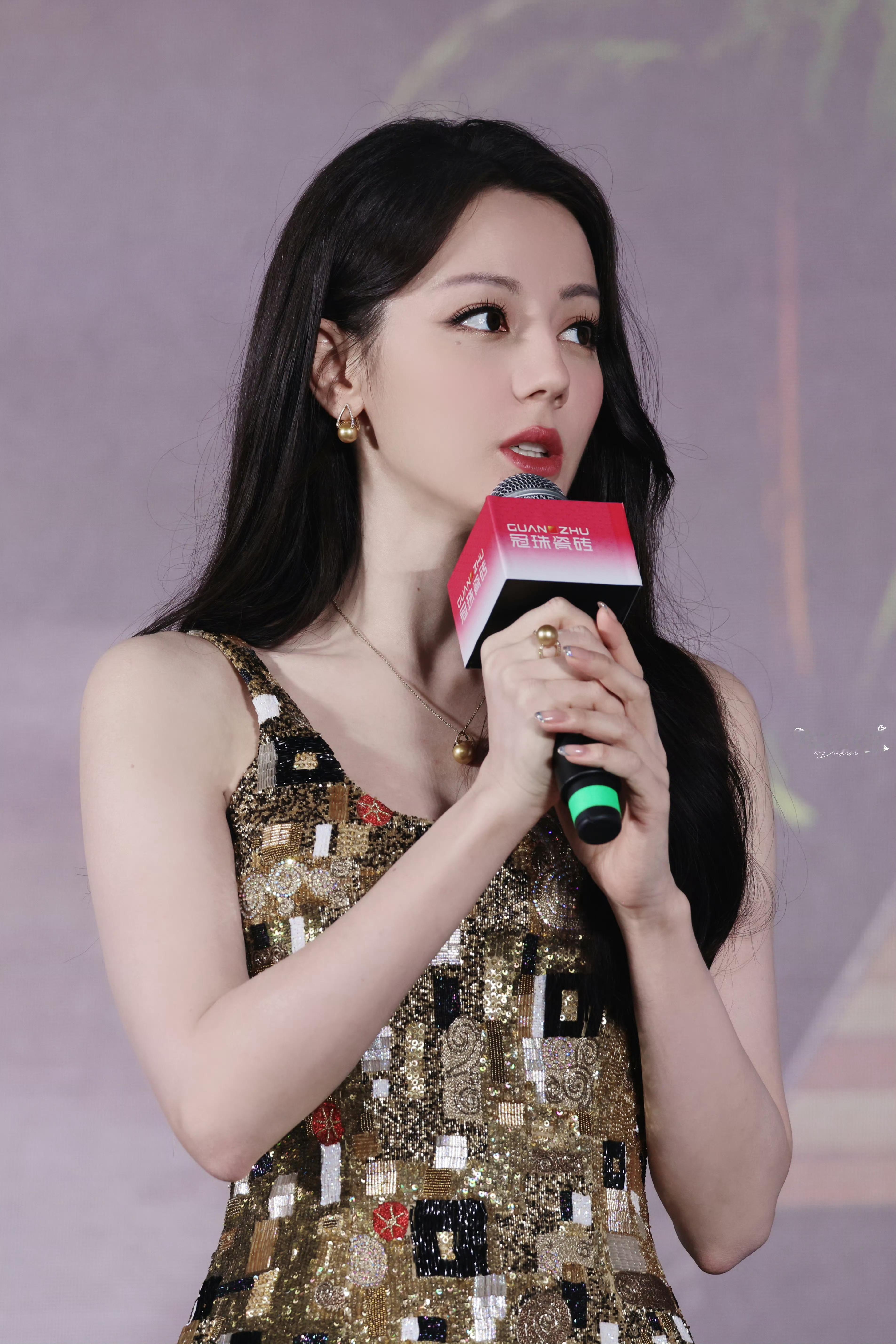 迪丽热巴长裙贴合曼妙身姿，亮片与几何图案交织，勾勒独特时尚感。乌黑长发自然垂落