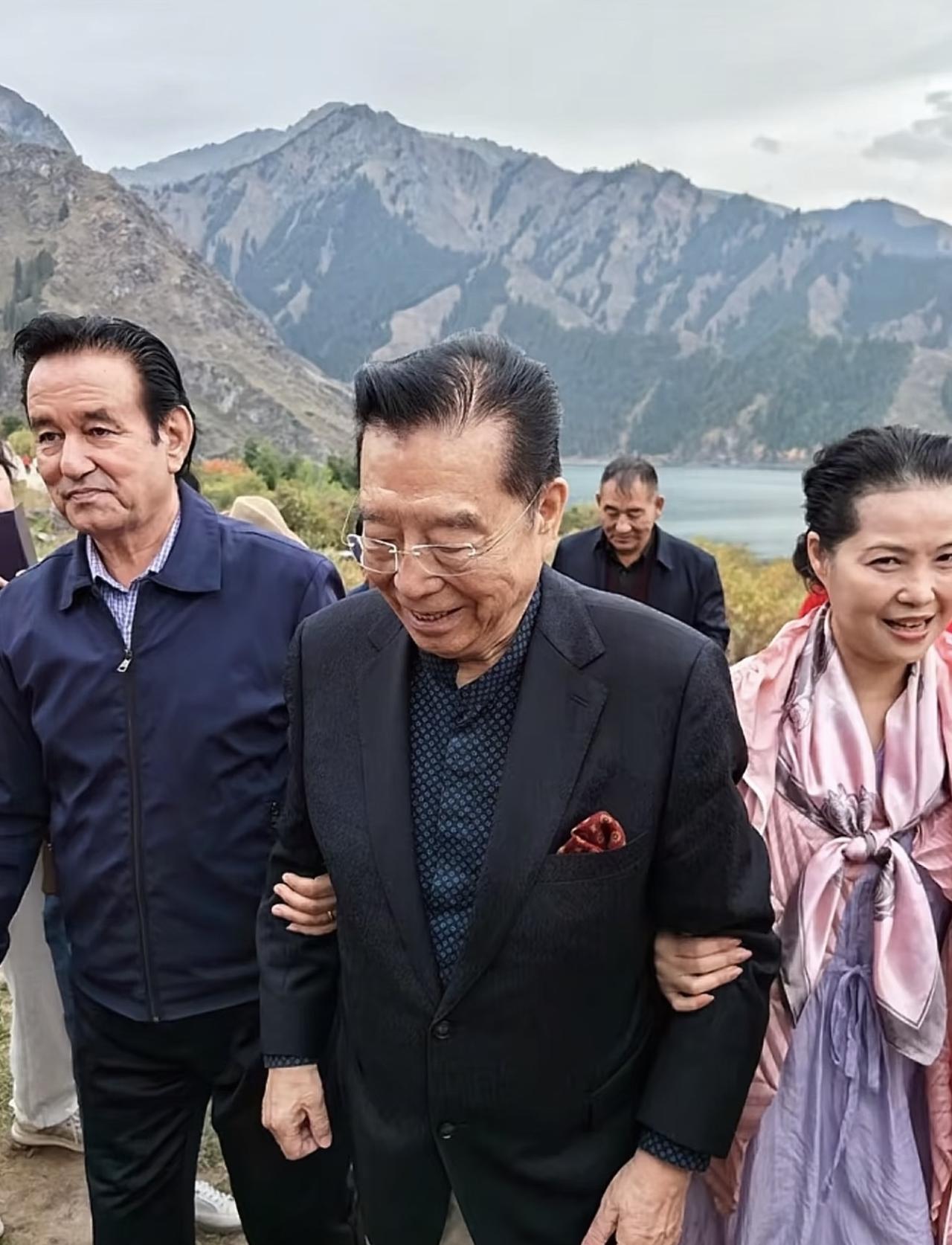 近日，李双江携妻子梦鸽到新疆游玩，夫妻俩现身天山池风景区的画面。86岁的李双江