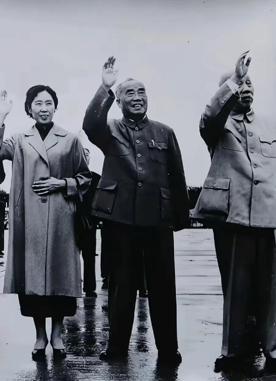 这张珍贵老照片从左至右依次为王光美、朱德元帅、董必武同志，三人在雨后的户外场合挥