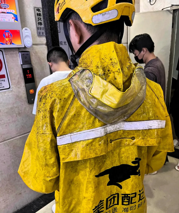 这外卖员一进电梯，旁边的人立刻往后退了两步。雨衣上全是霉斑，袖口黑得发亮。两