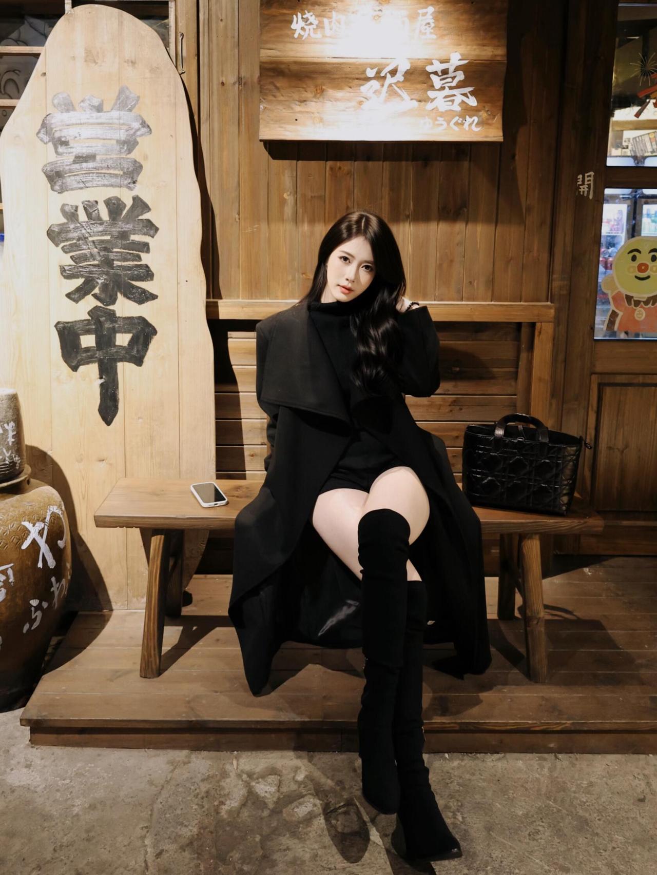 在夜色中，她静坐街角，黑色大衣，包裹着孤独的灵魂。长靴踏过岁月的门槛，每一