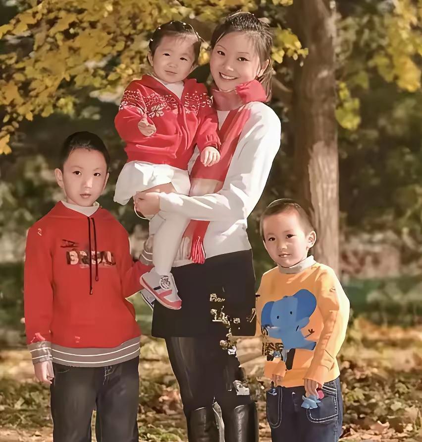 这是张艺谋妻子陈婷年轻时，与三个孩子的合影照。照片中的陈婷抱着女儿，两个儿子站