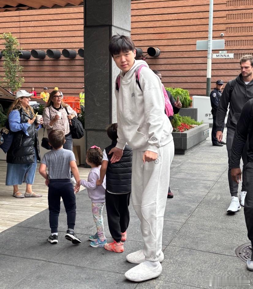 杨瀚森和外国小球迷们合影，还背着前几天的粉色小书包，看来小杨是真喜欢[大笑]​