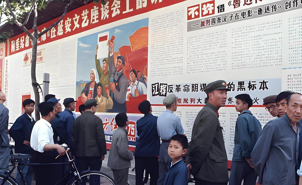 这张照片，展现的是“文革”那时候的场景。画面里，一群人正站在贴着大幅宣传画和批判