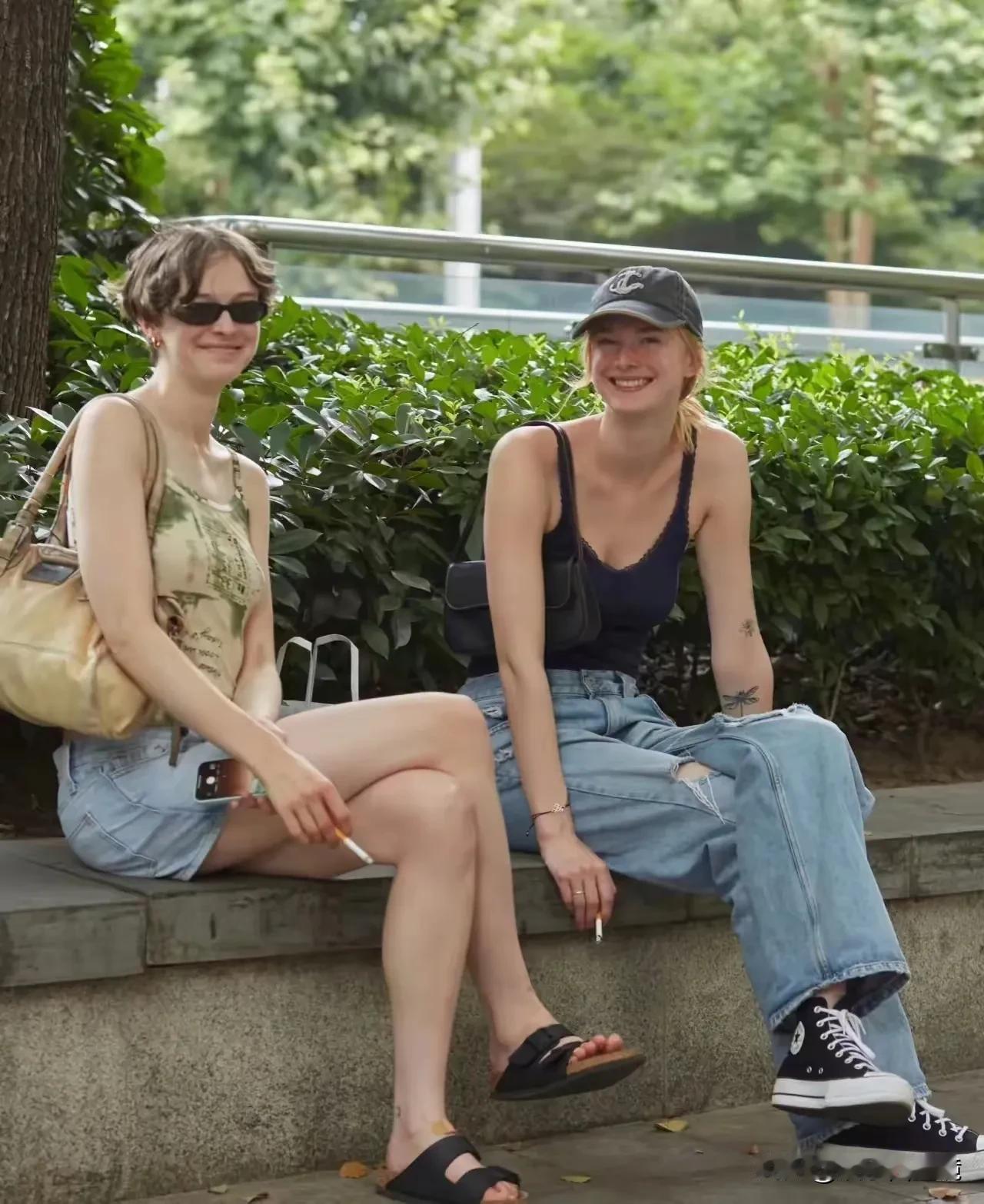 上海街头，二个外国女人坐在绿化带吸烟的情景。从照片上看，这两个女人看起来很放松