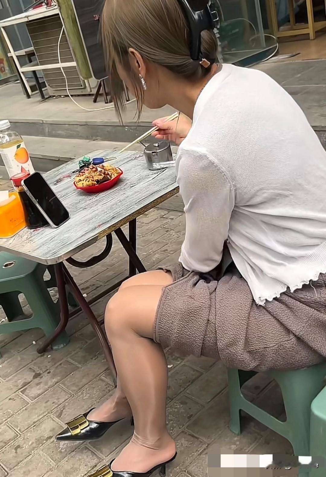 美女在街边吃面，腿好细。