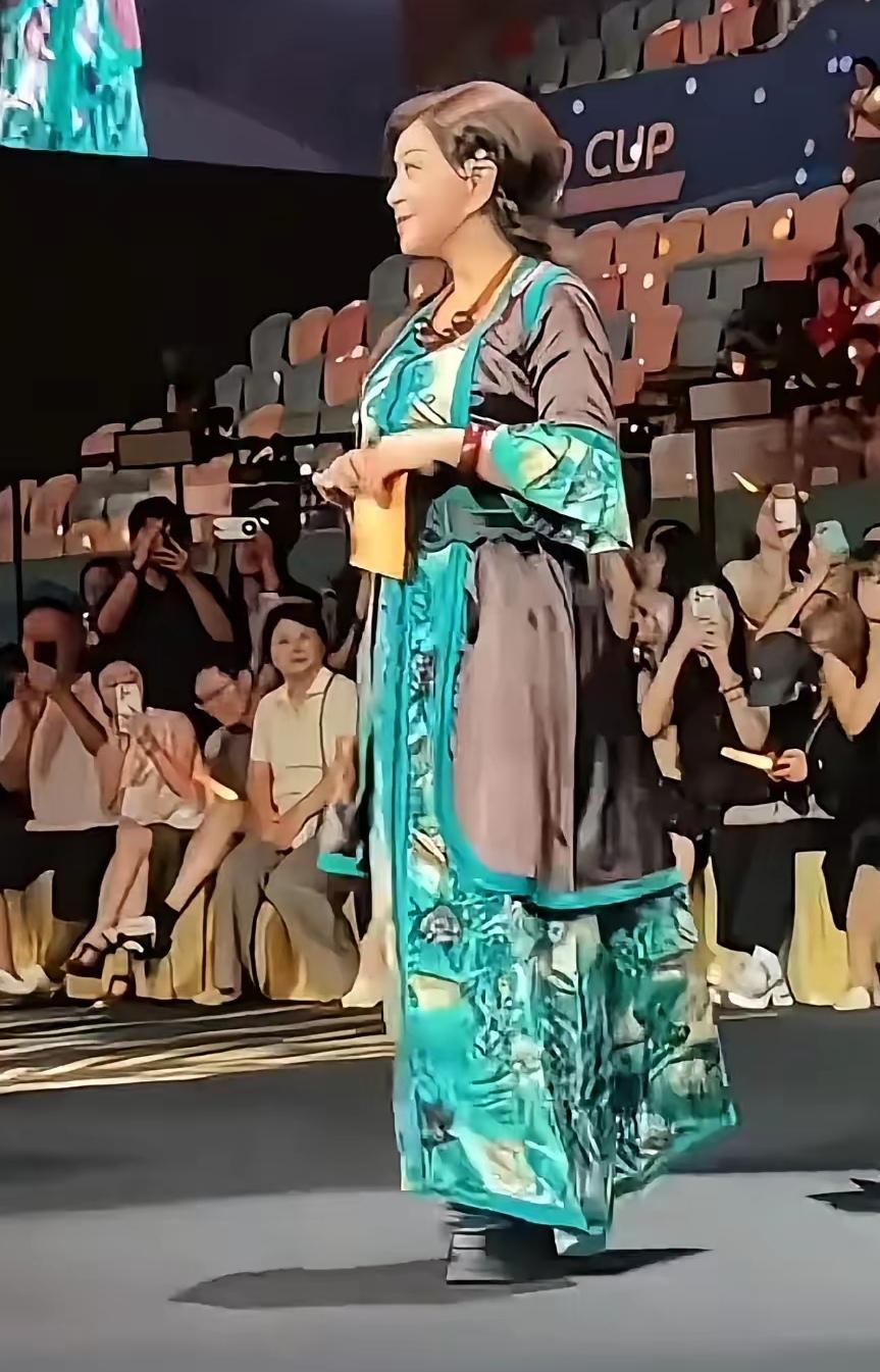 一看这穿着打扮就知道是刘晓庆。刘晓庆从来就喜欢花花绿绿的衣服。每次出镜必须花苕，