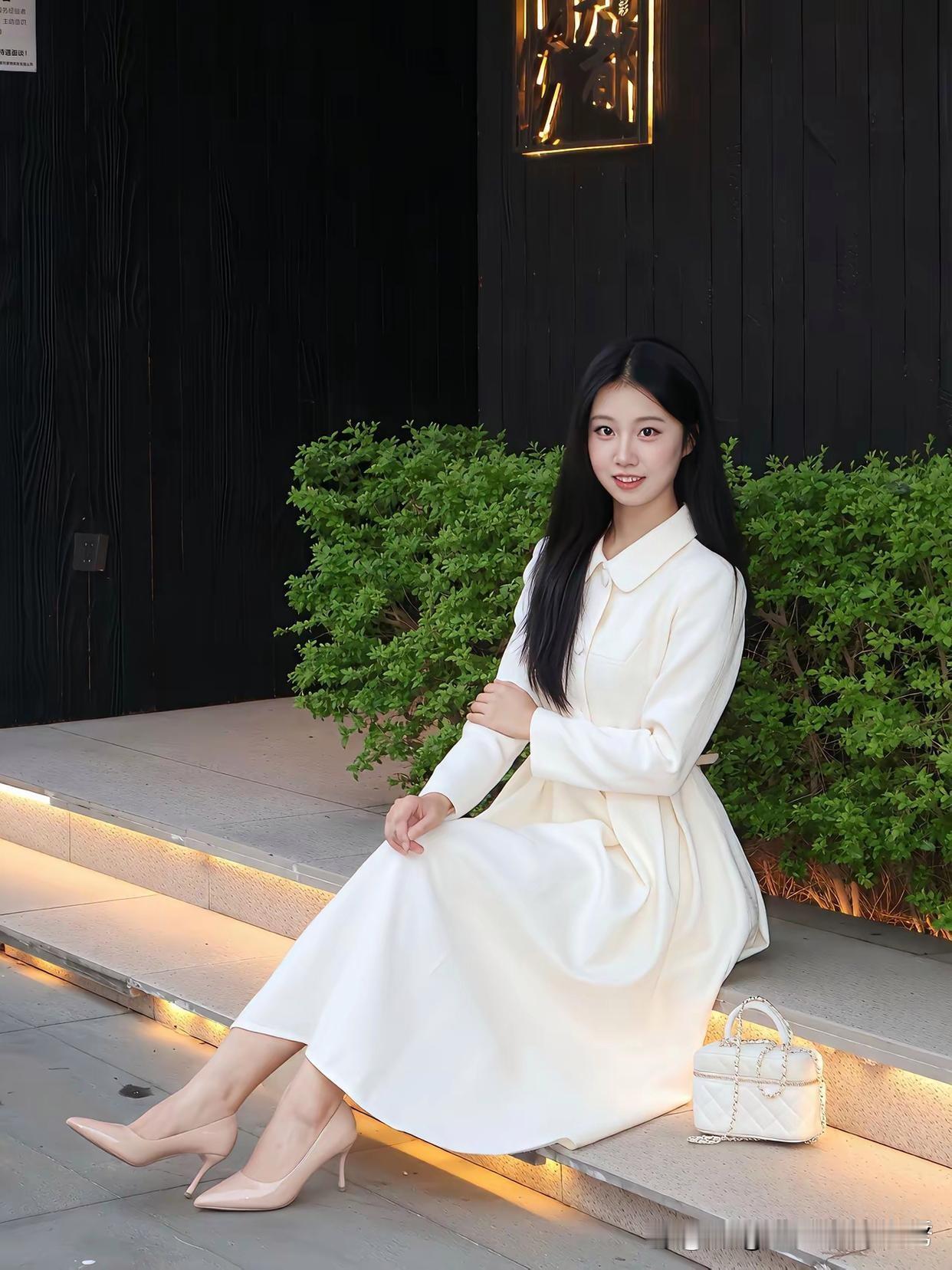 想象一下，身着优雅白裙，静静坐在绿植旁，那是何等惬意的宁静时光。就像李沁的绝美写