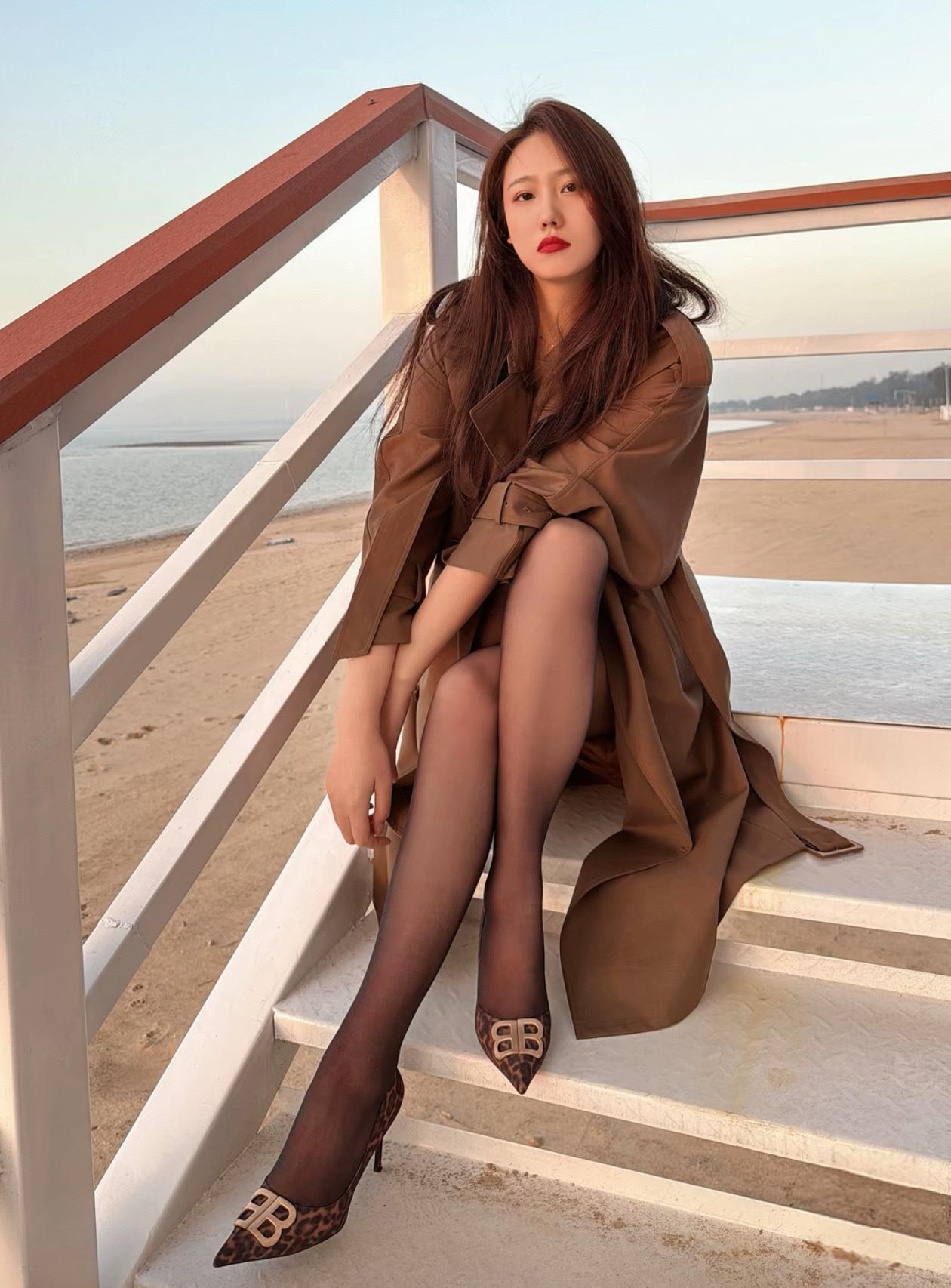 海边漫步，优雅穿搭，红唇与海风相得益彰。