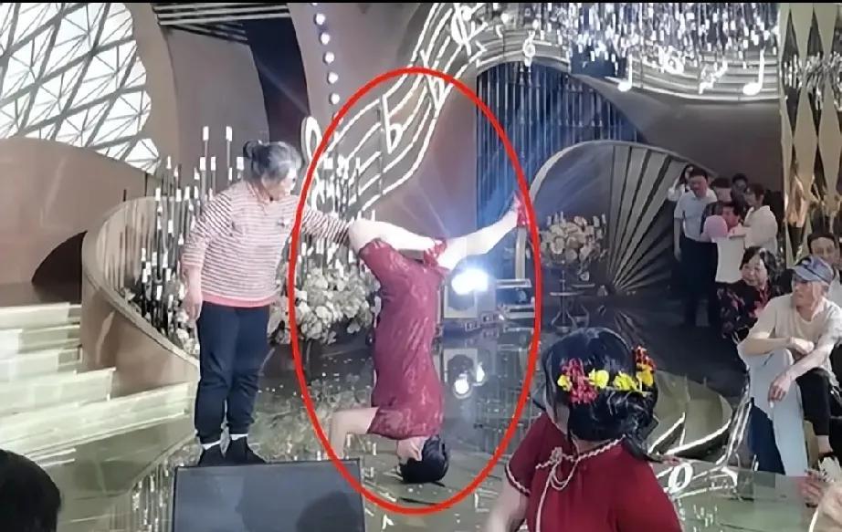 婚宴上喜婆婆穿短旗袍表演倒立劈叉，本想来个惊艳全场，结果旁边老太太全程死死按住她