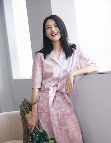 高圆圆近日代言夏装系列，她身穿粉色花裙，乌黑飘逸的秀发，灿烂明媚的笑容，手拿鲜花