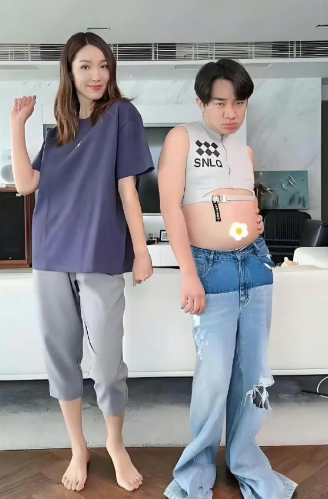 1米63的王祖蓝把裤子递给1米75的妻子。李亚男往上一套，裤脚直接缩水，紧绷地